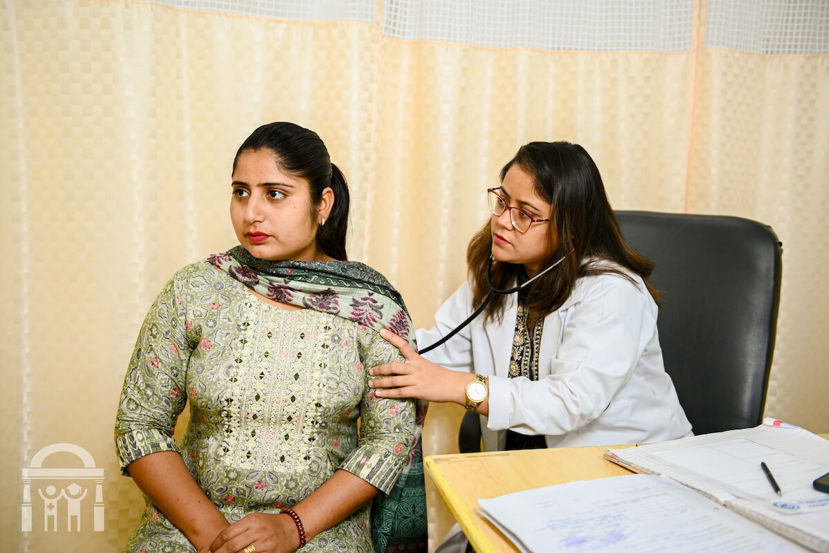 Doctor checking breathing of female patient at Guru Nanak Mission Hospital Dhahan Kaleran