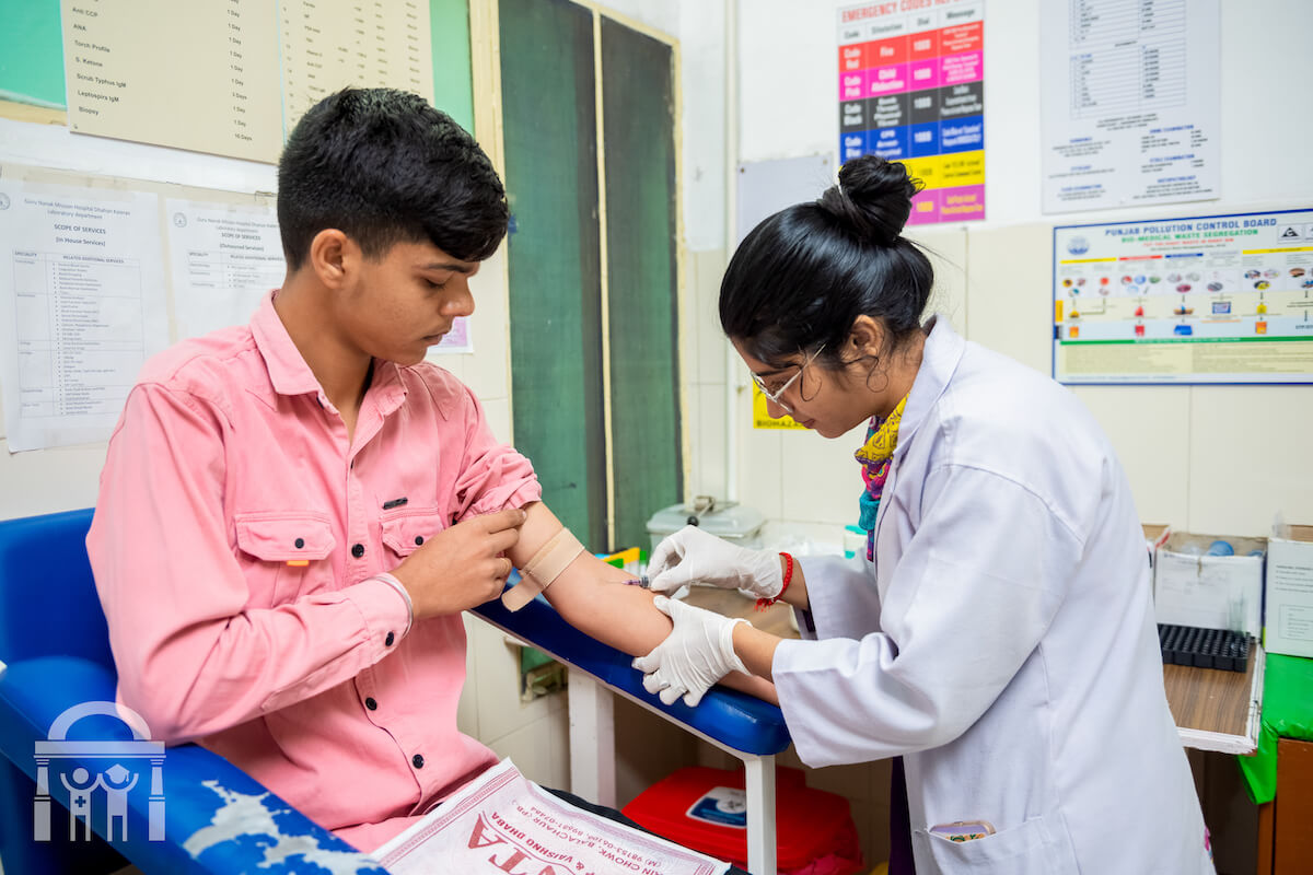 Drawing blood from a young patient at Guru Nanak Mission Hospital Dhahan Kaleran near Banga