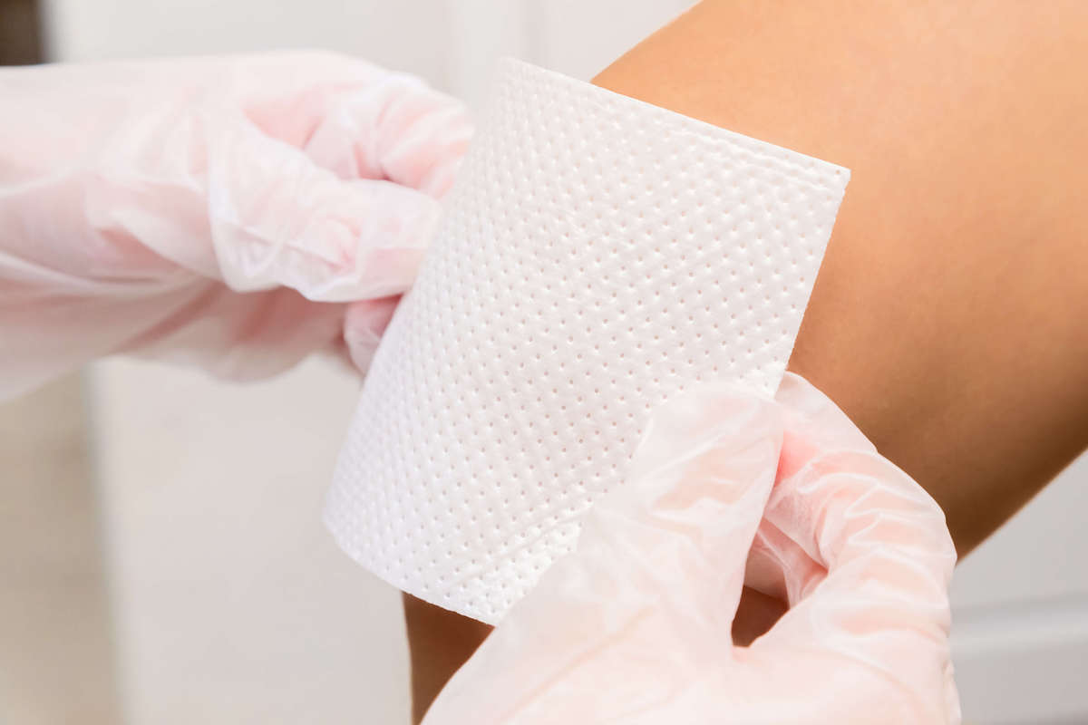 Dressing being placed on leg - dermatology concept