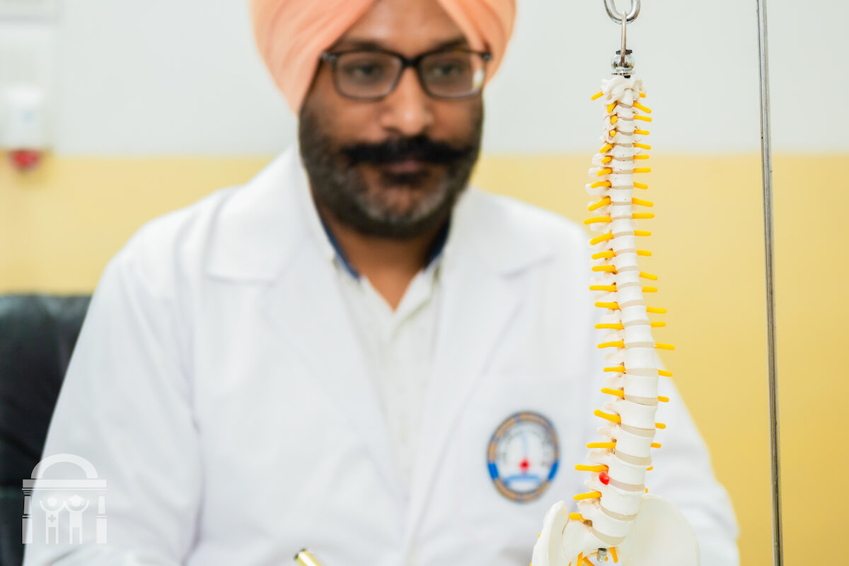 Neurosurgeon looking at model of spine at Guru Nanak Mission Hospital Dhahan Kaleran near Banga and Phagwara in Punjab