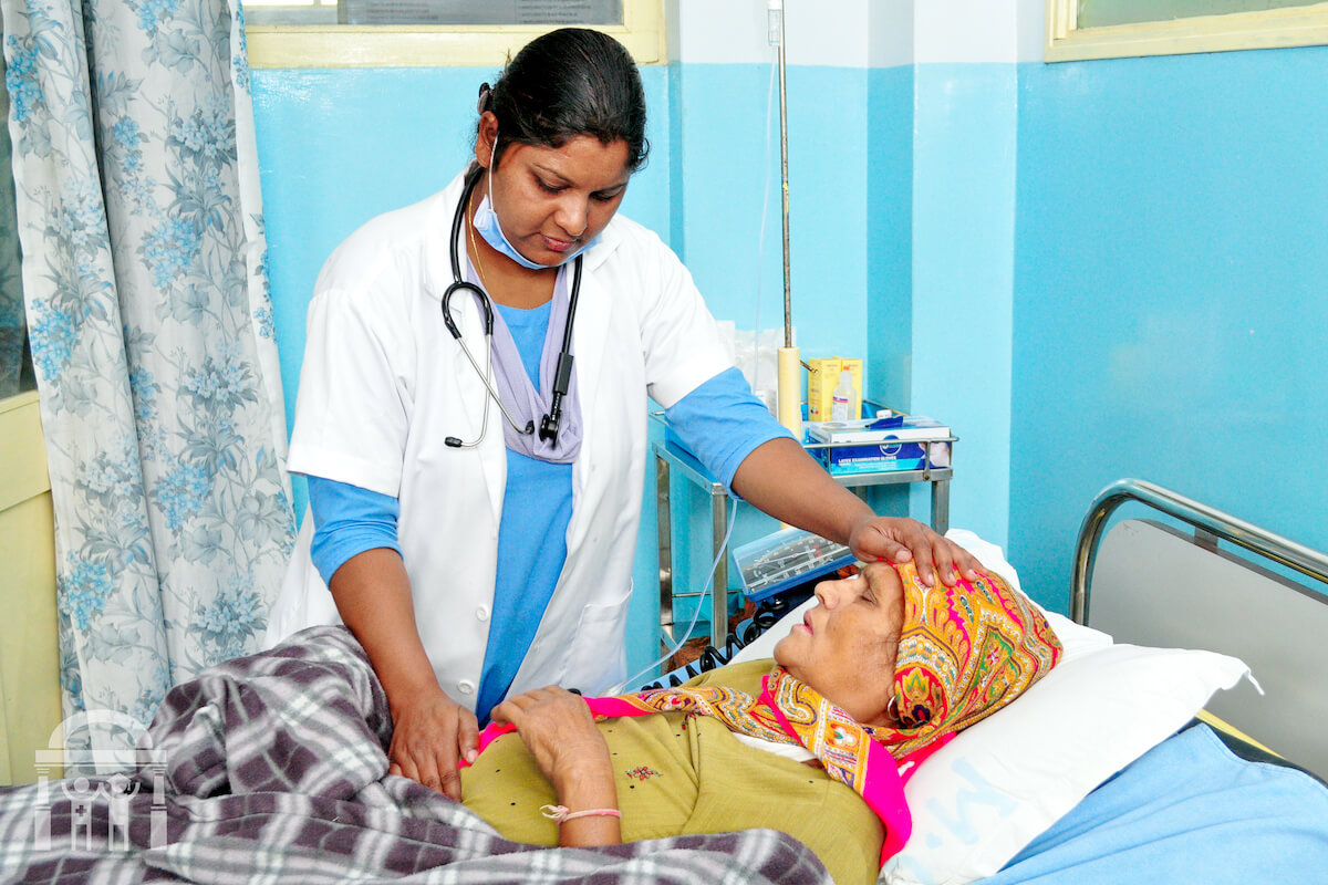Nurse checking on sick patient at Guru Nanak Mission Hospital Dhahan Kaleran near Banga
