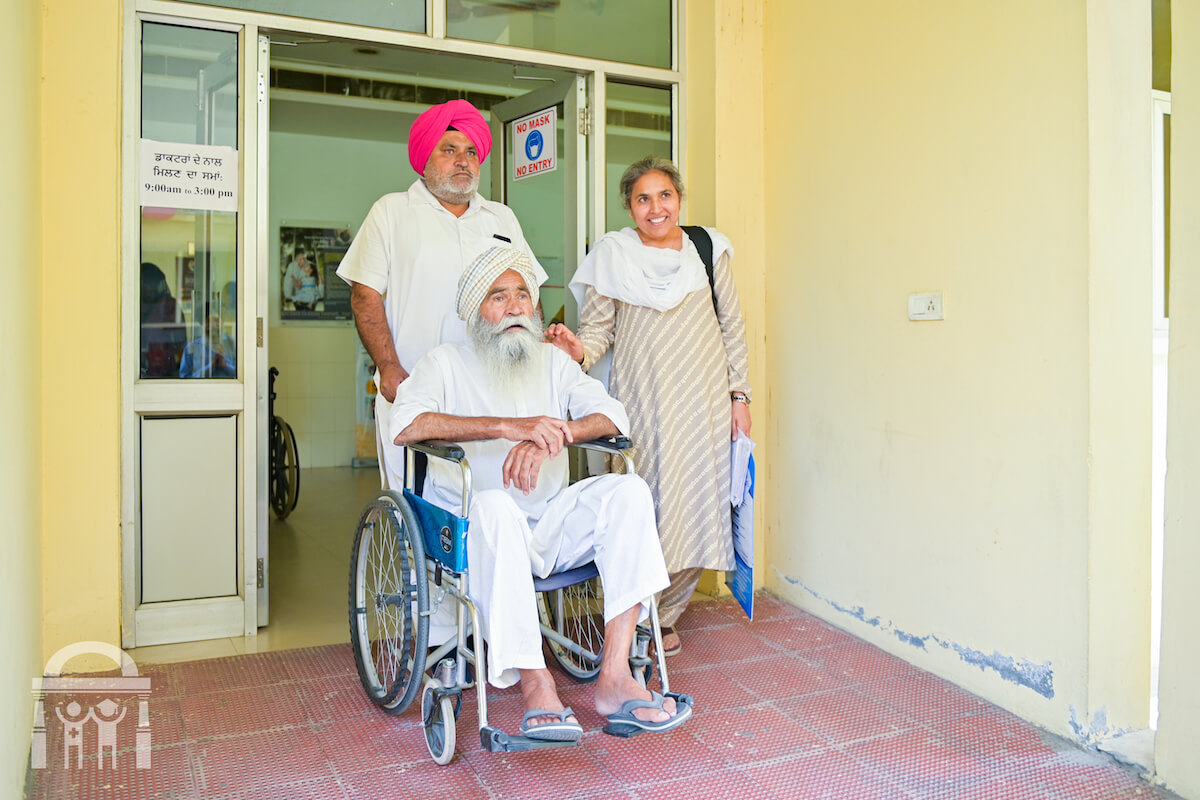 Patient leaving Guru Nanak Mission Hospital Dhahan Kaleran in wheelchair near Banga
