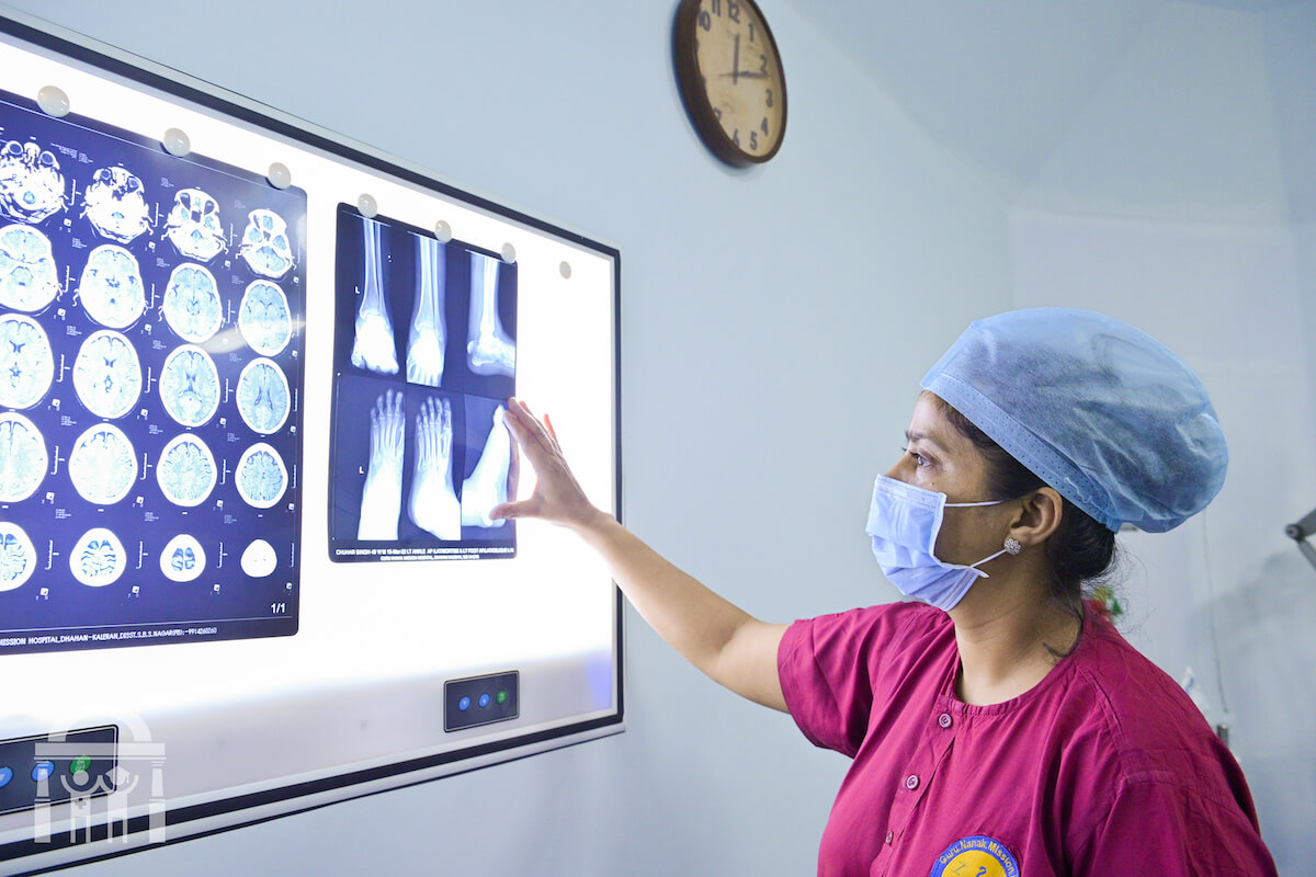Surgical assistant viewing X-rays and scans in an operating theatre at Guru Nanak Mission Hospital Dhahan Kaleran near Banga in Punjab